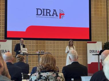 (Billedtekst) DIRA's sekretariatschef Søren Peter Johansen (t.v.) havde fået chefen for strategiske mærkesager i DI Produktion Charlotte Bisserup til at motivere og afsløre vinderen af DIRA Automatiseringsprisen 2024; AVK International, i forbindelse med